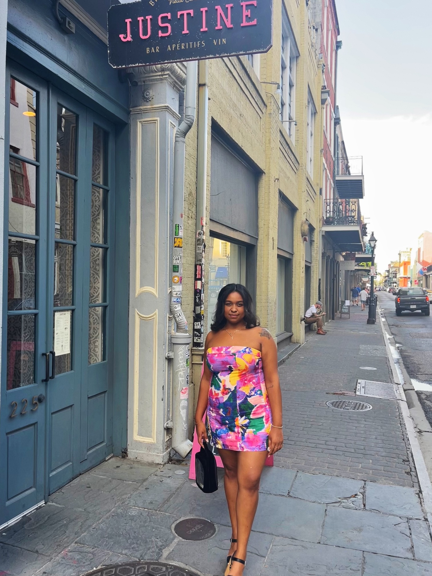 Taylor, founder of Bloom Street, standing outside Justine bar in the French Quarter in a floral dress